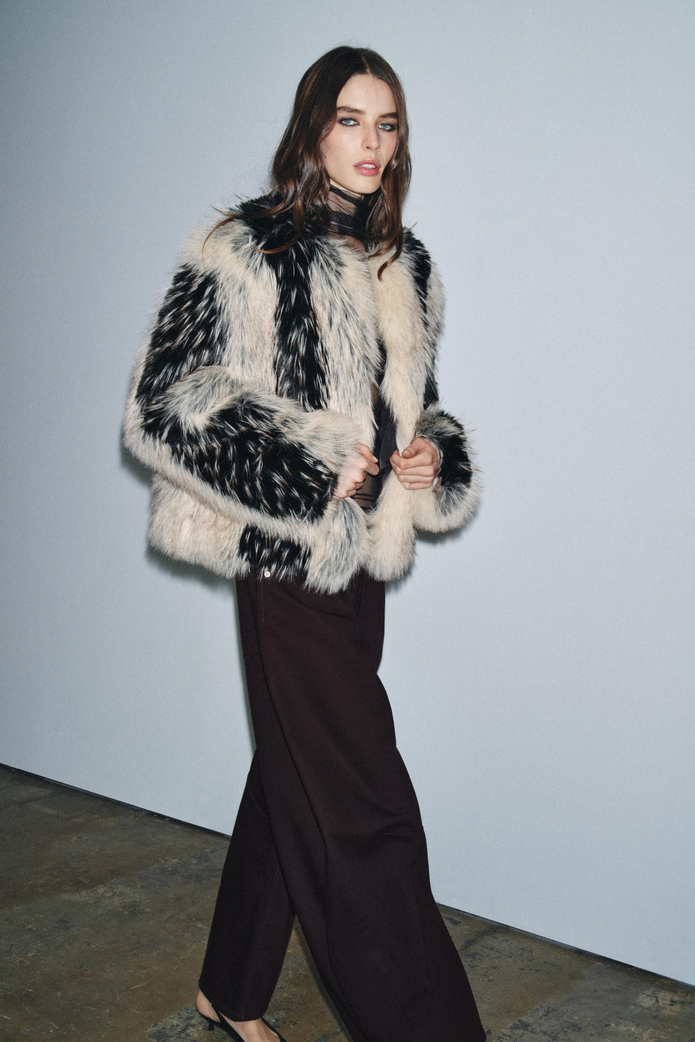 Solayne faux fur jas zwart crème – model zijaanzicht tijdens lopen