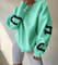 mintgroene oversized sweatshirt met zwarte CHICAGO NEW YORK opdruk op mouwen