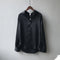Une chemise en satin noir élégante accrochée à un cintre. Elle possède un col classique, des manches longues avec des poignets boutonnés et une coupe fluide qui lui confère un style moderne et sophistiqué.